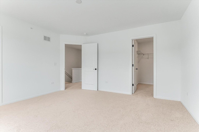 1121 Girard Ave, Des Plaines, IL 60018 - unfurnished bedroom featuring light carpet, a spacious closet, baseboards, and a closet