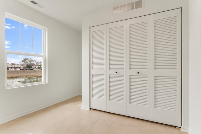 1121 Girard Ave, Des Plaines, IL 60018 - unfurnished bedroom with a closet, baseboards, and light tile patterned floors
