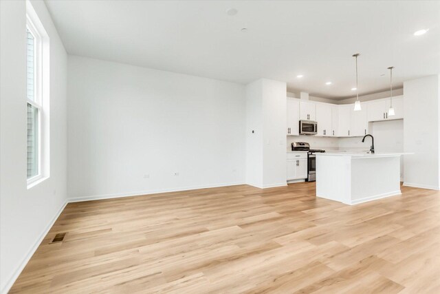 1121 Girard Ave, Des Plaines, IL 60018 - kitchen featuring stainless steel appliances, a sink, open floor plan, light wood finished floors, and recessed lighting