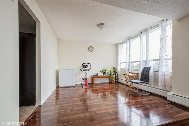 unfurnished room featuring dark wood-style floors, baseboards, and a textured ceiling