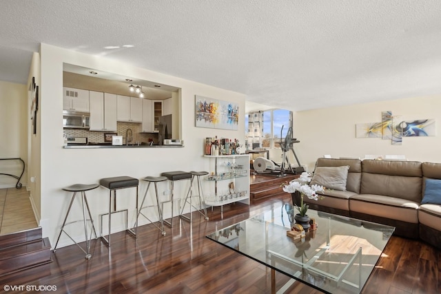 living area featuring dark wood-style floors and a textured ceiling