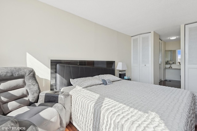 bedroom featuring two closets and wood finished floors