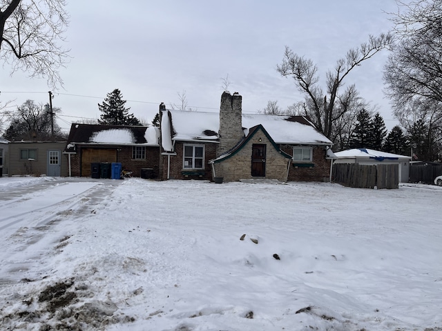 snow covered rear of property with fence