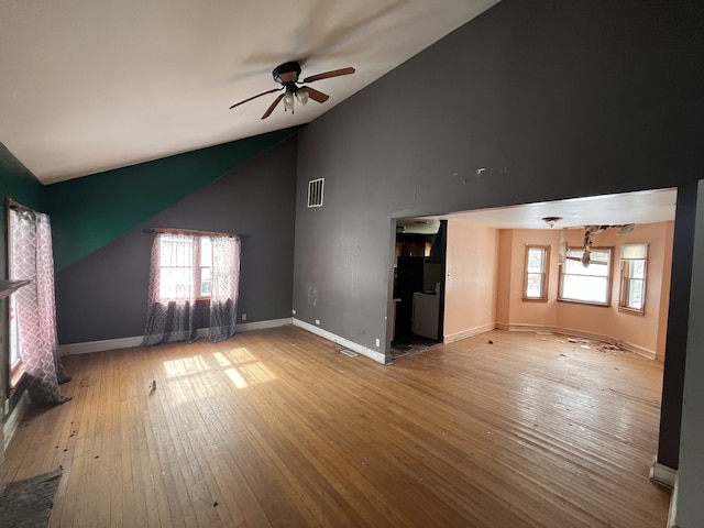 unfurnished living room with a ceiling fan, visible vents, baseboards, and hardwood / wood-style floors