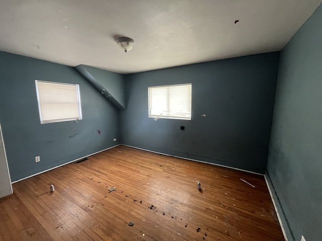 unfurnished room with visible vents and hardwood / wood-style flooring