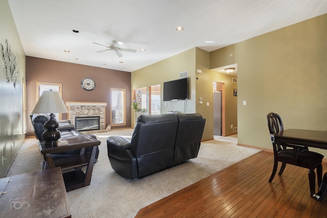 living room with recessed lighting, a ceiling fan, baseboards, a brick fireplace, and wood-type flooring