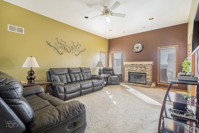 living area with a brick fireplace, carpet flooring, visible vents, and a ceiling fan