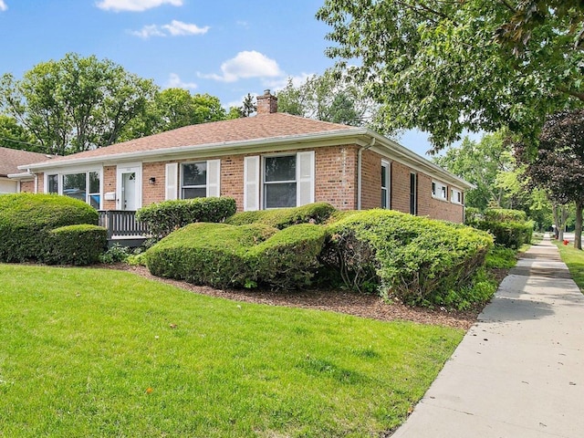 single story home with brick siding, a chimney, and a front lawn