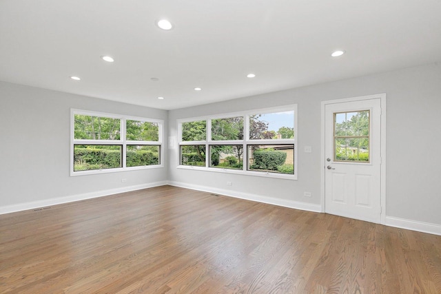 unfurnished room featuring light wood-type flooring, visible vents, baseboards, and recessed lighting