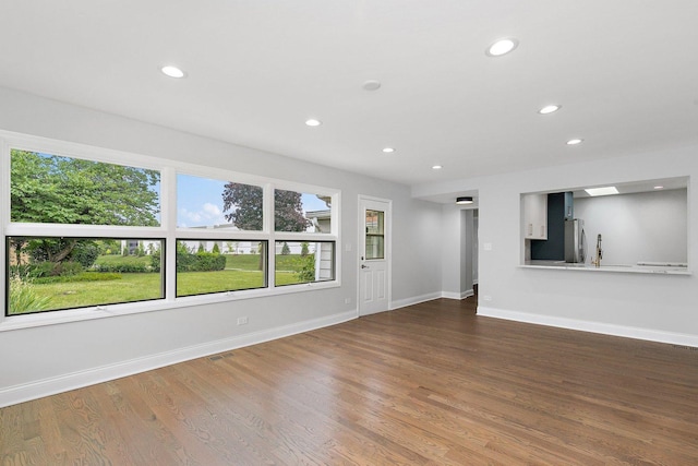 unfurnished living room featuring recessed lighting, baseboards, and wood finished floors