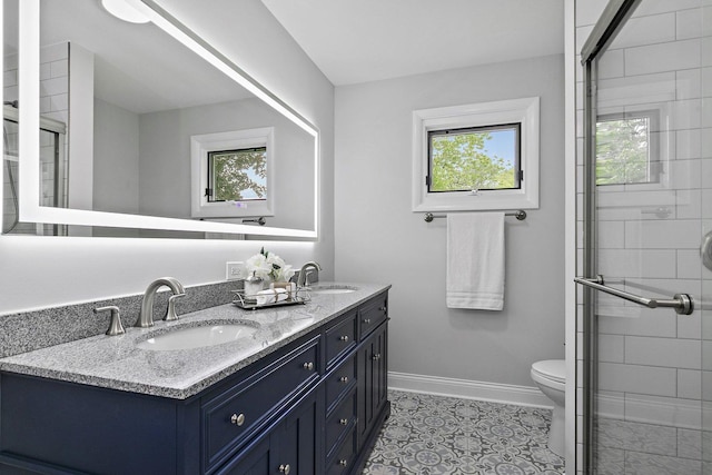 full bath with double vanity, baseboards, toilet, and a sink