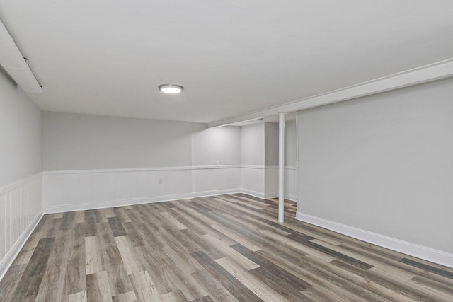 finished below grade area featuring a wainscoted wall and light wood-type flooring