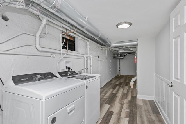 washroom with laundry area, wainscoting, dark wood-style flooring, and washing machine and clothes dryer