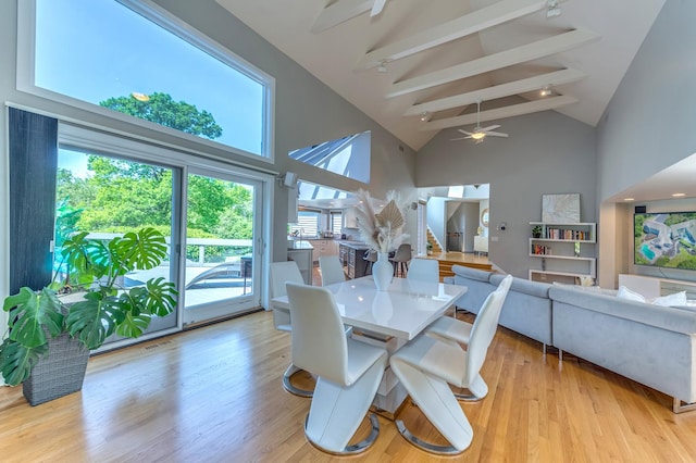 dining area featuring visible vents, stairway, light wood-type flooring, high vaulted ceiling, and beam ceiling