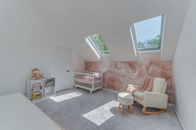 bedroom featuring light carpet, lofted ceiling with skylight, and baseboards