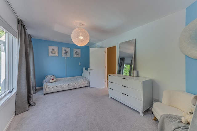 bedroom with light carpet and multiple windows