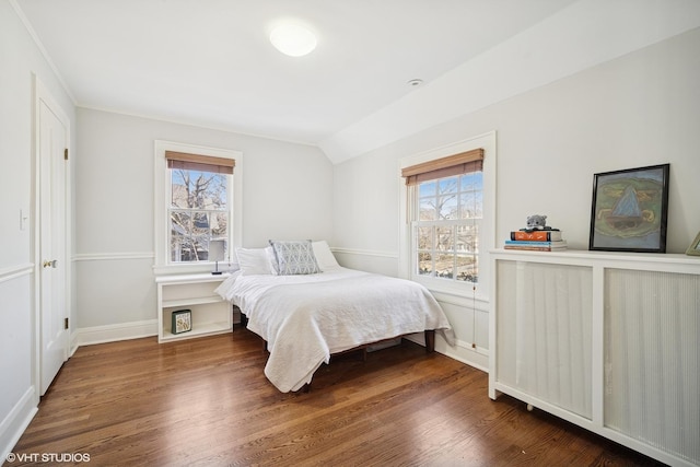 bedroom with lofted ceiling, baseboards, and wood finished floors