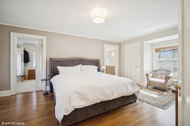 bedroom with ornamental molding, baseboards, and wood finished floors