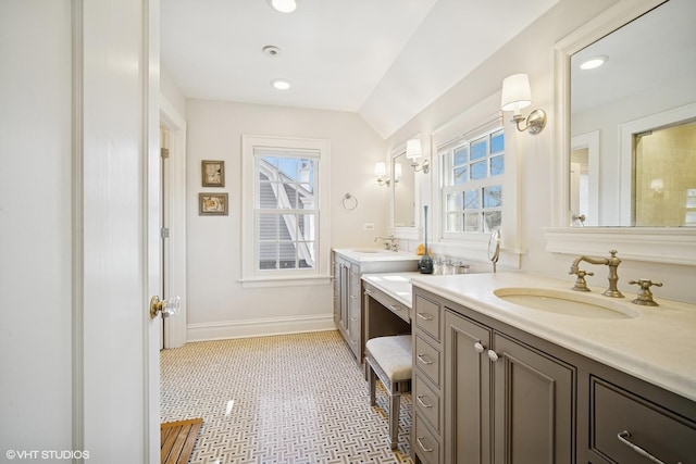 bathroom featuring recessed lighting, two vanities, a sink, and baseboards