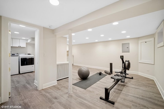 exercise area featuring recessed lighting, light wood-style flooring, washer and dryer, electric panel, and baseboards