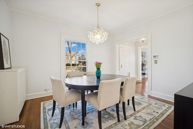 dining space featuring baseboards, a notable chandelier, ornamental molding, and wood finished floors