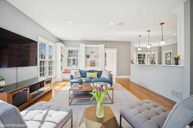 living room with recessed lighting, visible vents, light wood finished floors, and an inviting chandelier