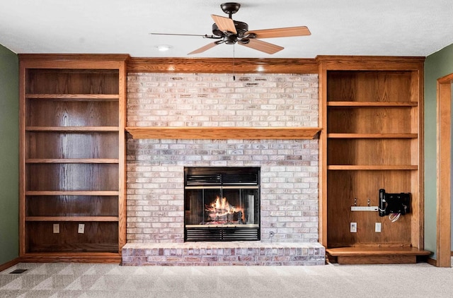 unfurnished living room featuring a ceiling fan, carpet flooring, a fireplace, and visible vents