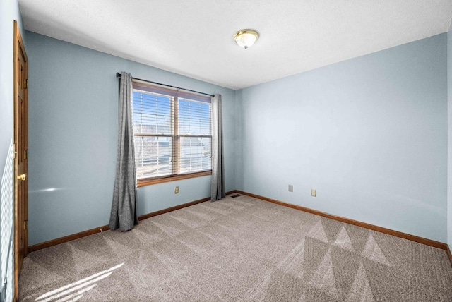 unfurnished room with carpet floors and baseboards