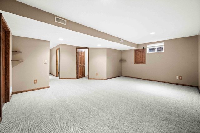 below grade area featuring light colored carpet, visible vents, baseboards, and recessed lighting