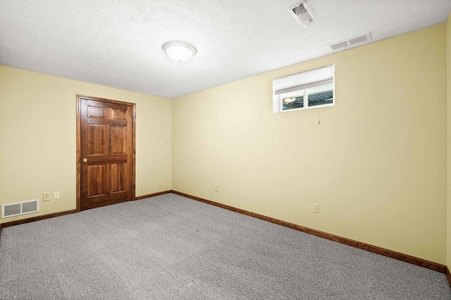 empty room featuring baseboards, a textured ceiling, visible vents, and carpet flooring