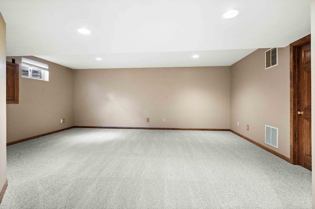 spare room featuring carpet, visible vents, and baseboards