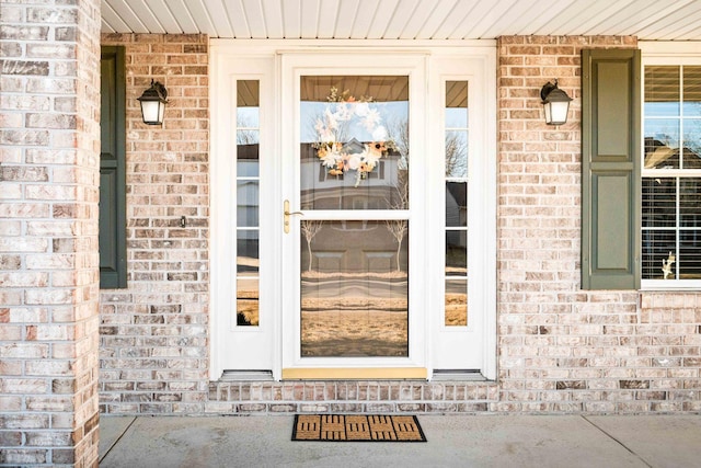 entrance to property featuring brick siding