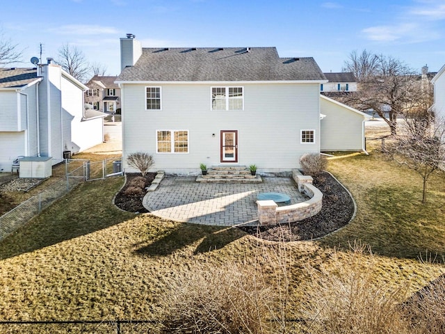 rear view of property featuring a chimney, roof with shingles, a gate, fence, and a patio area