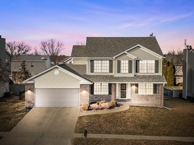 traditional-style house featuring concrete driveway, brick siding, roof with shingles, and an attached garage