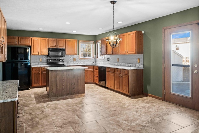 kitchen featuring light stone counters, a sink, brown cabinets, black appliances, and tasteful backsplash