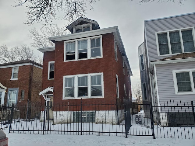 view of front facade with a fenced front yard and brick siding