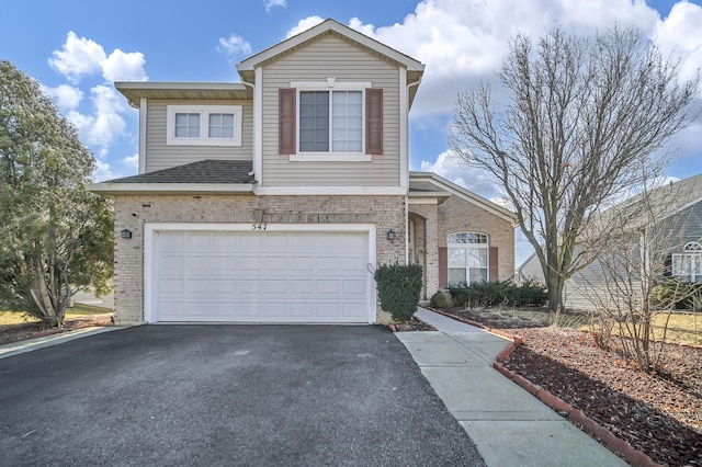 traditional-style house featuring aphalt driveway, brick siding, and a garage