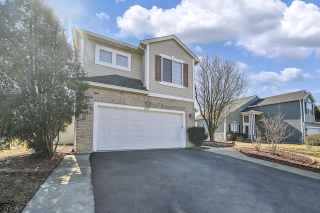 traditional-style house with brick siding, driveway, and an attached garage