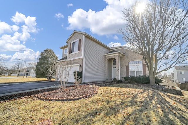 view of front facade with driveway, an attached garage, and brick siding