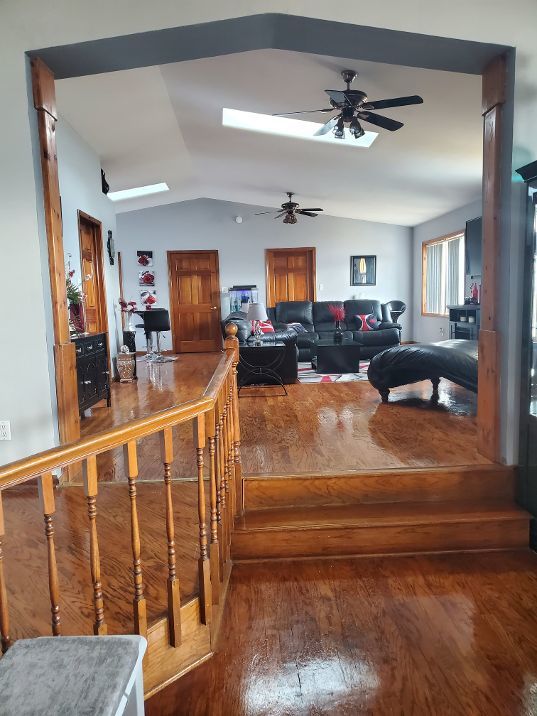 living room featuring lofted ceiling, ceiling fan, and wood finished floors