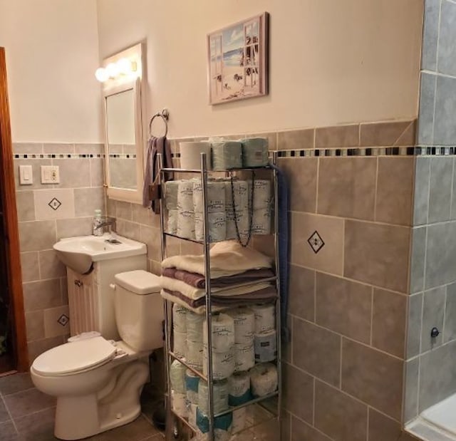 bathroom featuring toilet, tile patterned flooring, vanity, and tile walls