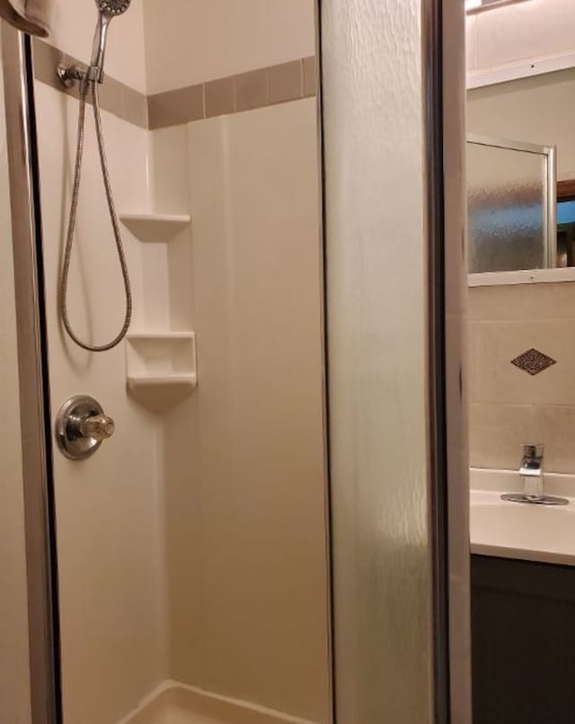 full bathroom featuring walk in shower and vanity