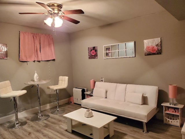 living room with ceiling fan, wood finished floors, and baseboards