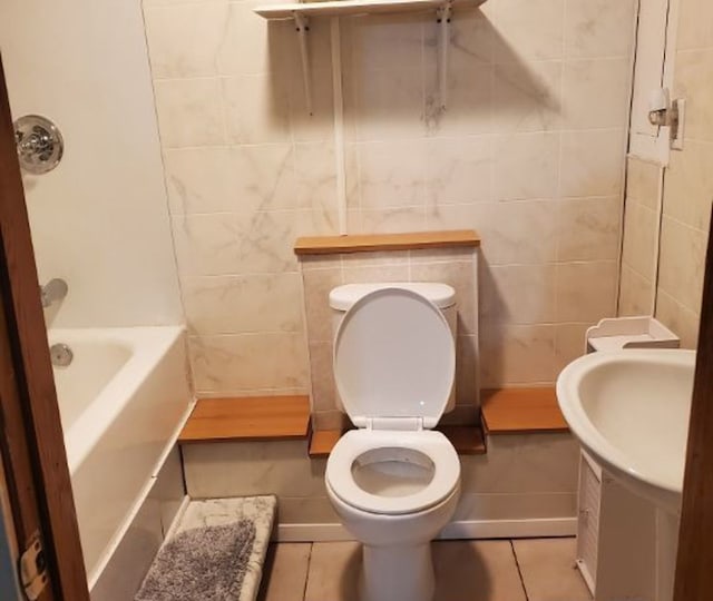 full bath featuring toilet, tile patterned flooring, and tile walls