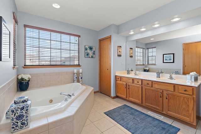 bathroom with double vanity, visible vents, a sink, a jetted tub, and tile patterned floors