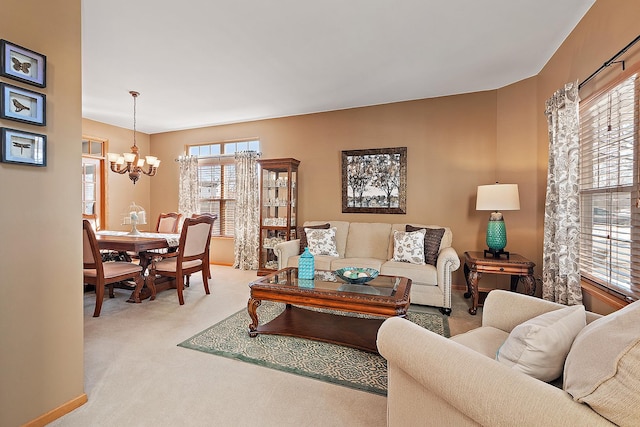 living area featuring plenty of natural light, carpet flooring, and a notable chandelier