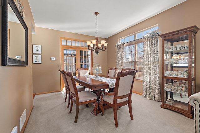 dining space with light carpet, baseboards, visible vents, and a notable chandelier