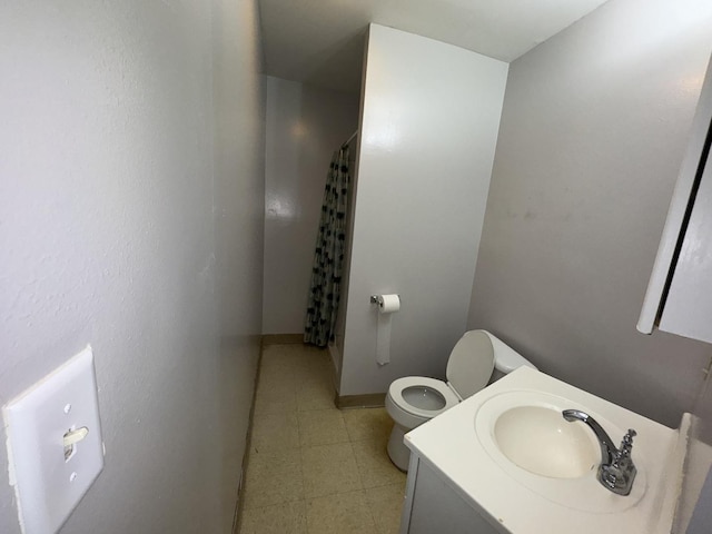 bathroom featuring a stall shower, vanity, toilet, and tile patterned floors