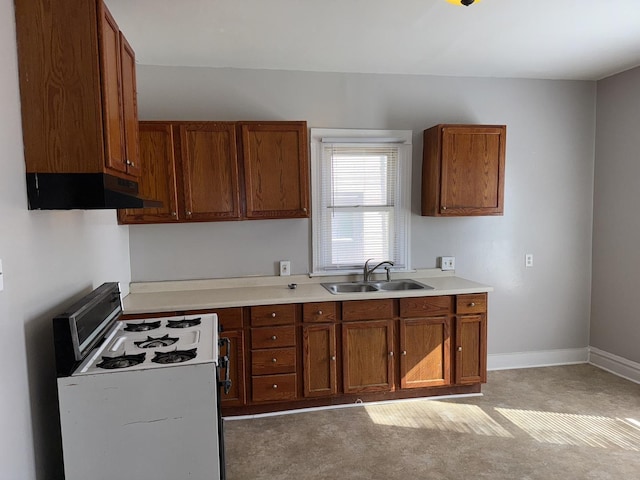 kitchen with white gas stove, a sink, light countertops, ventilation hood, and brown cabinetry