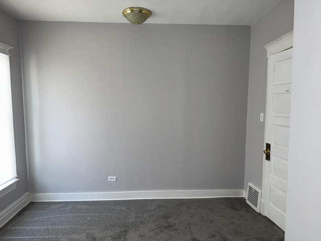 empty room with baseboards and dark colored carpet